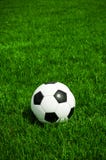 Balón de fútbol clásico que miente en la hierba, es un día soleado en verano foto de archivo Balón de fútbol clásico que miente en la hierba, es un día soleado en verano foto de archivo