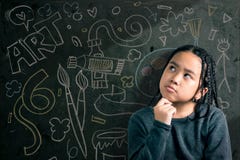 Bambina astuta che sorride davanti ad una lavagna immagini stock Bambina astuta che sorride davanti ad una lavagna immagini stock