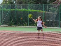 Bambina che gioca a tennis sulla corte fotografia stock Bambina che gioca a tennis sulla corte fotografia stock
