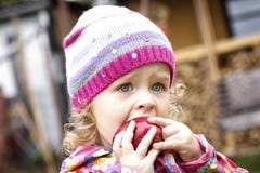 Bambina che mangia mela in autunno fotografia stock Bambina che mangia mela in autunno fotografia stock