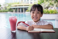Bambina cinese asiatica che fa compito Fotografia Stock Libera da Diritti Bambina cinese asiatica che fa compito Fotografia Stock Libera da Diritti