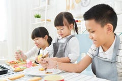 Bambini che decorano i biscotti immagine stock libera da diritti Bambini che decorano i biscotti immagine stock libera da diritti