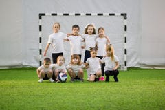Bambini che giocano a calcio all'interno Squadra di football americano dei bambini immagini stock Bambini che giocano a calcio all'interno Squadra di football americano dei bambini immagini stock