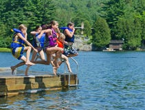 Bambini che hanno divertimento di estate che salta giù bacino nel lago immagine stock libera da diritti Bambini che hanno divertimento di estate che salta giù bacino nel lago immagine stock libera da diritti