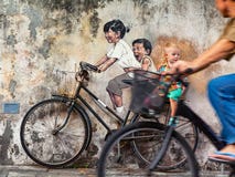 Bambini dell'oggetto di arte della via sulla bicicletta a Georgetown Penang immagine stock Bambini dell'oggetto di arte della via sulla bicicletta a Georgetown Penang immagine stock