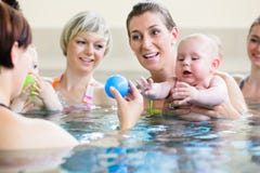 Bambini e le loro mamme alla classe di madre-e-bambino-nuoto fotografia stock Bambini e le loro mamme alla classe di madre-e-bambino-nuoto fotografia stock