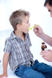Bambino che cattura la medicina di tosse fotografie stock Bambino che cattura la medicina di tosse fotografie stock