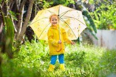 Bambino che gioca nella pioggia Bambino con l'ombrello immagini stock libere da diritti Bambino che gioca nella pioggia Bambino con l'ombrello immagini stock libere da diritti