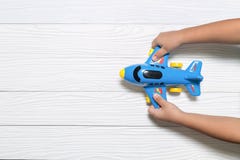 Bambino che tiene il giocattolo blu dell'aeroplano Concetto di immaginazione fotografia stock Bambino che tiene il giocattolo blu dell'aeroplano Concetto di immaginazione fotografia stock