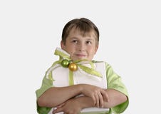 Bambino che tiene un presente spostato e che osserva meditatamente in su fotografia stock Bambino che tiene un presente spostato e che osserva meditatamente in su fotografia stock