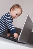 Bambino con il computer portatile fotografia stock Bambino con il computer portatile fotografia stock