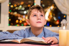 Bambino con il libro vicino alla candela fotografia stock libera da diritti Bambino con il libro vicino alla candela fotografia stock libera da diritti