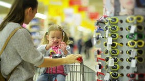 Bambino femminile felice con la sua abbastanza bella madre che sceglie gli occhiali da sole nel supermercato Ragazza sveglia con archivi video Bambino femminile felice con la sua abbastanza bella madre che sceglie gli occhiali da sole nel supermercato Ragazza sveglia con archivi video