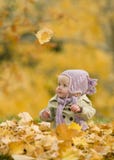 Bambino in fogli di autunno fotografie stock Bambino in fogli di autunno fotografie stock
