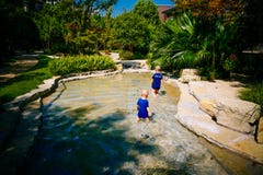 Bambino piccolo che gioca fuori nel fiume immagini stock Bambino piccolo che gioca fuori nel fiume immagini stock