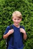 Bambino piccolo con Backback che si prepara per il suo primo giorno di scuola nel quarto grado fotografia stock libera da diritti Bambino piccolo con Backback che si prepara per il suo primo giorno di scuola nel quarto grado fotografia stock libera da diritti