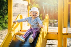 Bambino sorridente felice sul cursore al campo da giuoco all'aperto Immagine Stock Bambino sorridente felice sul cursore al campo da giuoco all'aperto Immagine Stock