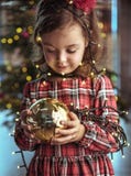 Bambino sveglio che tiene una palla di vetro dell'albero di Natale fotografie stock libere da diritti Bambino sveglio che tiene una palla di vetro dell'albero di Natale fotografie stock libere da diritti