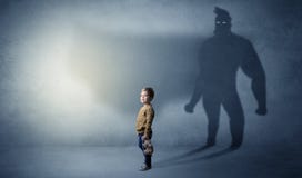 Bambino sveglio con l'ombra dell'eroe dietro fotografia stock Bambino sveglio con l'ombra dell'eroe dietro fotografia stock