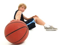 Bambino teenager del ragazzo in uniforme che si siede con la pallacanestro fotografie stock Bambino teenager del ragazzo in uniforme che si siede con la pallacanestro fotografie stock