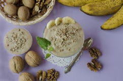 Bananowy lody deser z orzechami włoskimi na purpurowym tle zdjęcie stock Bananowy lody deser z orzechami włoskimi na purpurowym tle zdjęcie stock