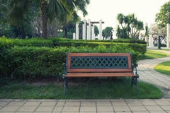 Banco vazio isolado em um parque público com jardim fotografia de stock Banco vazio isolado em um parque público com jardim fotografia de stock