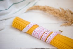 Bande de mesure avec le groupe de spaghetti italiens crus de pâtes, variétés de pâtes Régime, concept sain de nourriture images stock Bande de mesure avec le groupe de spaghetti italiens crus de pâtes, variétés de pâtes Régime, concept sain de nourriture images stock