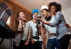 Bande multiraciale de musique exécutant dans un studio d'enregistrement images libres de droits Bande multiraciale de musique exécutant dans un studio d'enregistrement images libres de droits