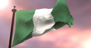 Bandeira de Nigéria que acena no vento em lento no por do sol, laço Bandeira de Nigéria que acena no vento em lento no por do sol, laço