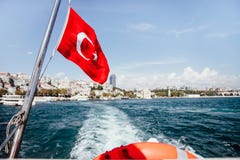 A bandeira de Turquia e o boia salva-vidas suportam sobre de um barco no passo de Bosphorus, Istambul, Turquia foto de stock A bandeira de Turquia e o boia salva-vidas suportam sobre de um barco no passo de Bosphorus, Istambul, Turquia foto de stock