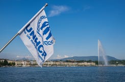 Bandeira do alto comissário de United Nations para os refugiados (UNHCR) que acenam no vento no lago geneva imagens de stock Bandeira do alto comissário de United Nations para os refugiados (UNHCR) que acenam no vento no lago geneva imagens de stock