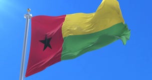 Bandera de Guinea-Bissau que agita en el viento en lento en el cielo azul, lazo Bandera de Guinea-Bissau que agita en el viento en lento en el cielo azul, lazo