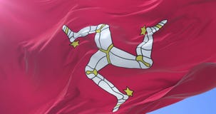 Bandera de la isla del hombre que agita en el viento con el cielo azul en lento, lazo Bandera de la isla del hombre que agita en el viento con el cielo azul en lento, lazo