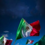 Banderas mexicanas contra un cielo nocturno, Día de la Independencia, cinco de ma imagen de archivo libre de regalías Banderas mexicanas contra un cielo nocturno, Día de la Independencia, cinco de ma imagen de archivo libre de regalías