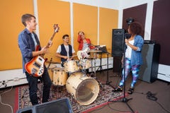 Bandleden die in Opnamestudio praktizeren royalty-vrije stock afbeeldingen Bandleden die in Opnamestudio praktizeren royalty-vrije stock afbeeldingen