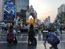 BANGKOK TAJLANDIA, KWIECIEŃ, - 16, 2018: Religijni ludzie one modlą się blisko buddist świątyni w centrum miasta z drapacz c obraz royalty free BANGKOK TAJLANDIA, KWIECIEŃ, - 16, 2018: Religijni ludzie one modlą się blisko buddist świątyni w centrum miasta z drapacz c obraz royalty free