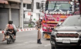 BANGKOK, THAILAND - JUNI 12: De naamloze verkeerspolitieagent geeft binnen een kaartje aan niet geïdentificeerde verkeersovertred stock foto BANGKOK, THAILAND - JUNI 12: De naamloze verkeerspolitieagent geeft binnen een kaartje aan niet geïdentificeerde verkeersovertred stock foto