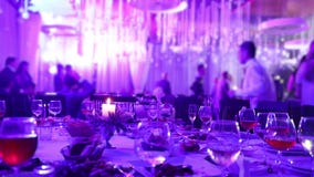 Banketlijst in een restaurant met glazen en een kaars De mensen dansen tegen de achtergrond van de lijst De lijst van het banket stock videobeelden Banketlijst in een restaurant met glazen en een kaars De mensen dansen tegen de achtergrond van de lijst De lijst van het banket stock videobeelden