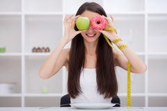 banta Härlig ung kvinna som väljer mellan frukt- och skräpfooen royaltyfri bild banta Härlig ung kvinna som väljer mellan frukt- och skräpfooen royaltyfri bild
