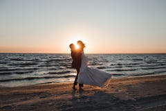 bara gift Härliga unga par på stranden på solnedgången royaltyfria bilder bara gift Härliga unga par på stranden på solnedgången royaltyfria bilder