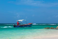 Barbadian men in red skirt on blue boat in azure water of Caribbean sea. Worthing beach. stock images Barbadian men in red skirt on blue boat in azure water of Caribbean sea. Worthing beach. stock images