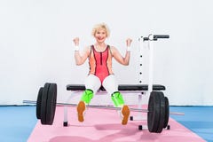 barbell de levage de sportive supérieure heureuse avec des jambes et le sourire photographie stock libre de droits barbell de levage de sportive supérieure heureuse avec des jambes et le sourire photographie stock libre de droits