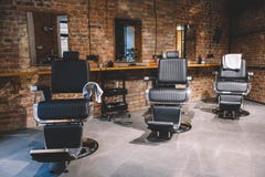Barbershop armchair, barber shop for men. Empty chairs in retro styled barbershop. Hair salon interior. Place for text or