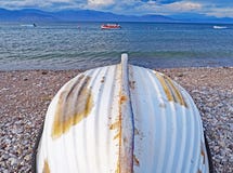 Barca rovesciata sulla spiaggia di Nikolaiika e sul golfo del Corinthian, Grecia fotografie stock Barca rovesciata sulla spiaggia di Nikolaiika e sul golfo del Corinthian, Grecia fotografie stock
