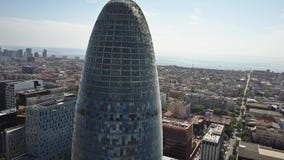 BARCELONA, ESPAÑA - ABRIL, 15, 2017 Cámara aérea que gira alrededor de la torre de Torre Agbar vídeo 4K almacen de video BARCELONA, ESPAÑA - ABRIL, 15, 2017 Cámara aérea que gira alrededor de la torre de Torre Agbar vídeo 4K almacen de video