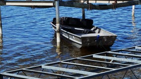 Barco de alumínio cinzento pequeno, usado por instaladores da doca para guardar o equipamento, flutuadores entre elevadores em um vídeos de arquivo Barco de alumínio cinzento pequeno, usado por instaladores da doca para guardar o equipamento, flutuadores entre elevadores em um vídeos de arquivo