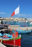 Barco de pesca colorido com a bandeira maltesa em Marsaxlokk, Malta fotos de stock Barco de pesca colorido com a bandeira maltesa em Marsaxlokk, Malta fotos de stock
