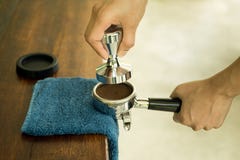 Barista, das gemahlenen Kaffee in portafilter unter Verwendung des Besetzers drückt Stockfoto Barista, das gemahlenen Kaffee in portafilter unter Verwendung des Besetzers drückt Stockfoto