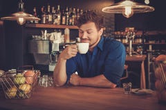 Barista die een nieuw type van koffie in zijn koffiewinkel proeven stock foto's Barista die een nieuw type van koffie in zijn koffiewinkel proeven stock foto's