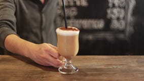 Barista putting cup of coffee down on counter in a cafe stock video Barista putting cup of coffee down on counter in a cafe stock video